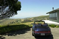 DAC's car parked in front of the house, looking out over the hills to the ocean.  