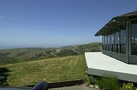 Showing the front deck (it surrounds the octagonal house), and the view towards the ocean from the parking area.  