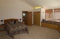 The master bedroom.  The entrance to the bath is to the right of the bed.  Doors to one of the three large closets are shown next to the master bath entrance.  The sitting platforms under the windows are all built-in drawers on ball-bearing sliders with lots of storage space.  