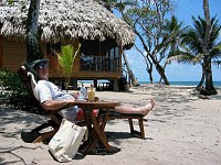 Doug relaxes with a Pina Colada and a book in front of our villa at Turtle Inn.  