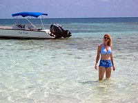 Margaret wades out towards our boat on Silk Caye.  