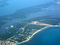 The view from &quotSofia&quot after take-off from Plancencia, looking back on the runway and Turtle Inn.  The runway is the long horizontal line in the picture, extending out on the narrow bridge across the lagoon.  The thatched roofs of Turtle Inn can just be seen in the extreme lower left-hand corner of the photo.  <br>