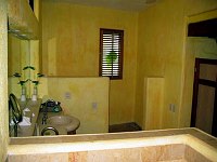 Toilet is behind the low walls at the far end.  